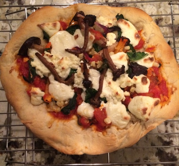 Veggie Pizza with farm fresh mushrooms, Tuscan kale, onions, red bell peppers, and fresh ricotta and mozzarella cheeses.  Garnished with sea salt, red pepper flakes, and a drizzle of olive oil.