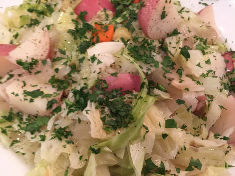 Boil red potatoes and the cabbage right in the same pot as the corned beef to infuse both with a nice, seasoned broth.  Finish with a bit of the juice and some Italian parsley.